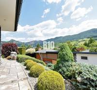 A beautiful garden at the villa in Súľov-Hradná with a view of the mountains and well-maintained vegetation.