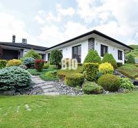 A villa in Súľov-Hradná with a beautiful garden and manicured shrubs.