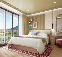 Bedroom in a two-room apartment with a bed, balcony doors, and a floor with a wooden decor.