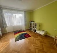 A room with a colorful carpet and a wooden decor floor in a 3-room apartment.
