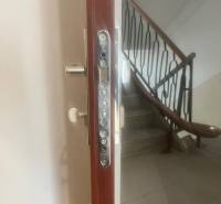 Security entrance door to a 3-room apartment, staircase with a handrail in the background.