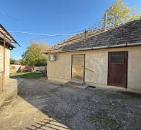 The courtyard of a family house on Malá Street in the town of Svätý Peter with older buildings and a garden.