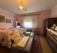 A bedroom in a family house with a wooden decor floor and vintage furniture.