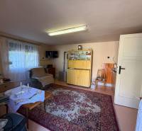 Living room in a family house with a carpet, antique furniture, and an armchair.