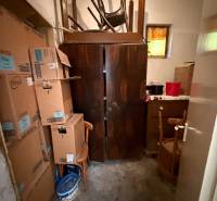 A storage room in a family house with cardboard boxes, old furniture, and closed doors.