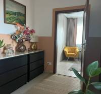 In the hallway of the 2-room apartment, there is a cabinet, decorations, and a yellow chair.