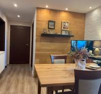 Dining area with a wooden table and decorations in a 2-room apartment.