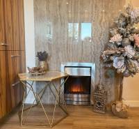 Decoration with an electric fireplace and a table with a vase in a 2-room apartment.