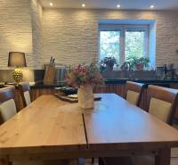 A kitchen with wooden furniture and flowers in a 2-room apartment.
