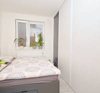 Bedroom with a bed, wardrobe, and plants in a 3-room apartment.