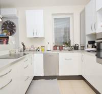 A kitchen in a 3-room apartment with white cabinets and built-in appliances.