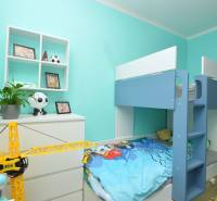 Children's room in a 3-room apartment with a bunk bed, toys, and turquoise walls.