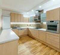 A kitchen in a 3-room apartment with a wooden decor, a countertop, and built-in appliances.