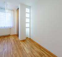 A room in a 3-room apartment with a wooden decor floor and a built-in radiator.