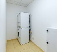 Laundry room in a 3-room apartment with a washing machine, dryer, and tiled floor.