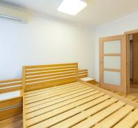 A bedroom in a 3-room apartment with wooden components and a floor with a wood decor.