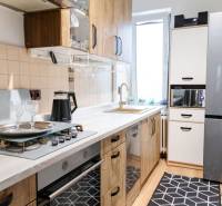 A kitchen in a 3-room apartment with a gas stove and white cabinets.