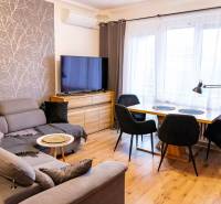 Living room in a 3-room apartment with a comfortable couch, wooden table, and floor with a wooden decor.