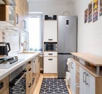 Kitchen in a 3-room apartment with appliances and flooring with a wood decor.