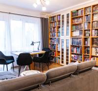 Living room in a 3-room apartment with a bookshelf and wooden decor flooring.