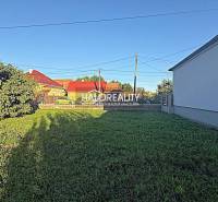 Plots - housing in Kameničná with grassy vegetation and surrounding development.
