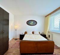 Bedroom in a 2-room apartment, wooden wardrobe, bed, lamps, and decorative curtains.