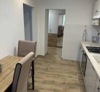 A kitchen with a table and a wooden floor decor in a studio apartment.