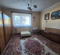 A room in a family house with carpets, wardrobes, a couch, a painting, a window with a view.