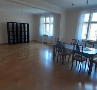 Bright living room with a table and chairs, wooden decor flooring in a 4-room apartment.
