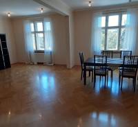 Dining area with a large table and a wooden decor floor in a 4-room apartment.