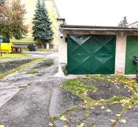 Garages on M. R. Štefánik Street in Detva with colorful containers and trees.