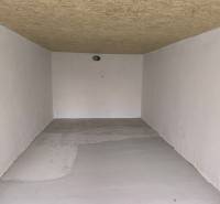 White garage with a wooden ceiling and concrete floor on M. R. Štefánika Street in Detva.