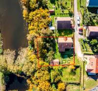 A family house in Medzev by the river and road, surrounded by greenery and neighboring houses.