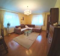 Living room in a family house with a wooden decor floor and a corner sofa.
