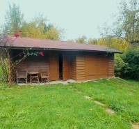 Garden house in Medzev surrounded by a garden and trees near a family house.