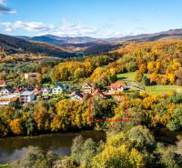 A family house in Medzev surrounded by autumn nature, with a view of the river and mountains.