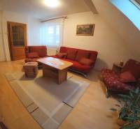Living room in a family house with a red sofa and a wooden decor floor.