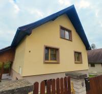 A family house in Medzev with a wooden terrace and stone fencing.