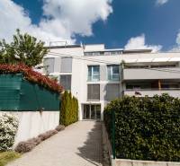 An apartment building on Eleventh Street in Bratislava - Nové Mesto surrounded by greenery and flowers.