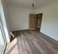 A room in a family house with a wooden decor floor and wooden doors.