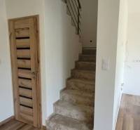 Interior of a family house with a wood-decorated floor and a staircase.
