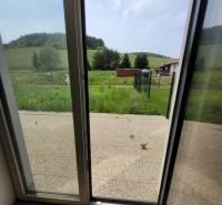 An open door leading to the terrace with a view of the garden, in a family house.
