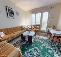 Living room in a 3-room apartment with a colorful sofa and a decorative carpet.