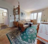 Living room with wood-patterned flooring, bright space in a 3-room apartment.