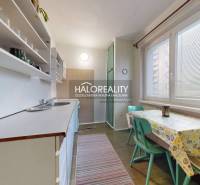 Kitchen in a 3-room apartment with a table and chairs, light decoration, practical arrangement.