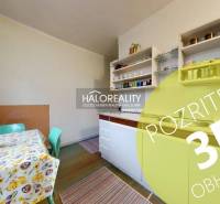 A kitchen in a 3-room apartment with a colorful table and shelves. Floor with wood decor.