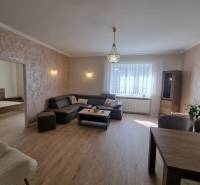 A bright living room with a sofa, table, and a view of the bedroom in a 3-room apartment.
