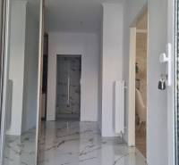 A hallway with marble flooring and radiators in a 3-room apartment, entrance to the room.