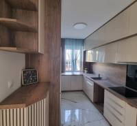 A stylish kitchen with wooden details, a spacious countertop, and modern equipment for a 3-room apartment.