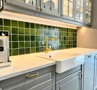 A kitchen in a family house with ceramic tiles and a sink.